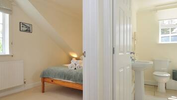 A bedroom with a bed, a bedside lamp, and a window.