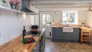 Una cocina moderna con encimera de madera, horno empotrado y un amplio ventanal.