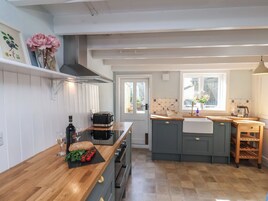 Una cocina moderna con encimera de madera, horno empotrado y un amplio ventanal.