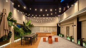 A modern indoor space with a dining area, a kitchen, and a balcony with string lights. - Stey-Shenzhen Qianhai Hotel & Apartment (Shenzhen)