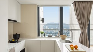 A modern kitchen with a view of a cityscape, a large window, and a sink. - Stey-Shenzhen Qianhai Hotel & Apartment (Shenzhen)