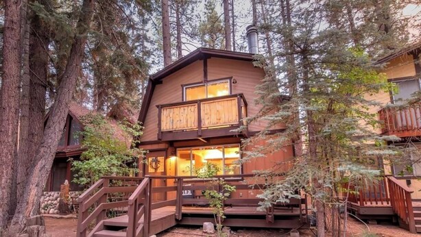 A cabin with a wooden exterior, a balcony, and a staircase leading to the entrance. - Summit Happy Mountain Cabin (Big Bear Lake)