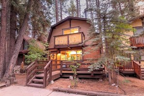 Een chalet met een houten gevel, een balkon en een trap naar de ingang.