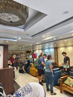 Un moderno vestíbulo de hotel con zonas de estar, un bar e iluminación empotrada en el techo.