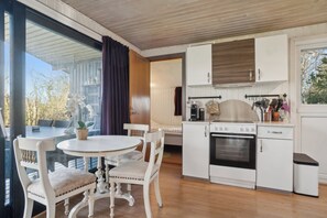 Une cuisine de taille réduite avec des meubles blancs, une cuisiniÚre et un évier.