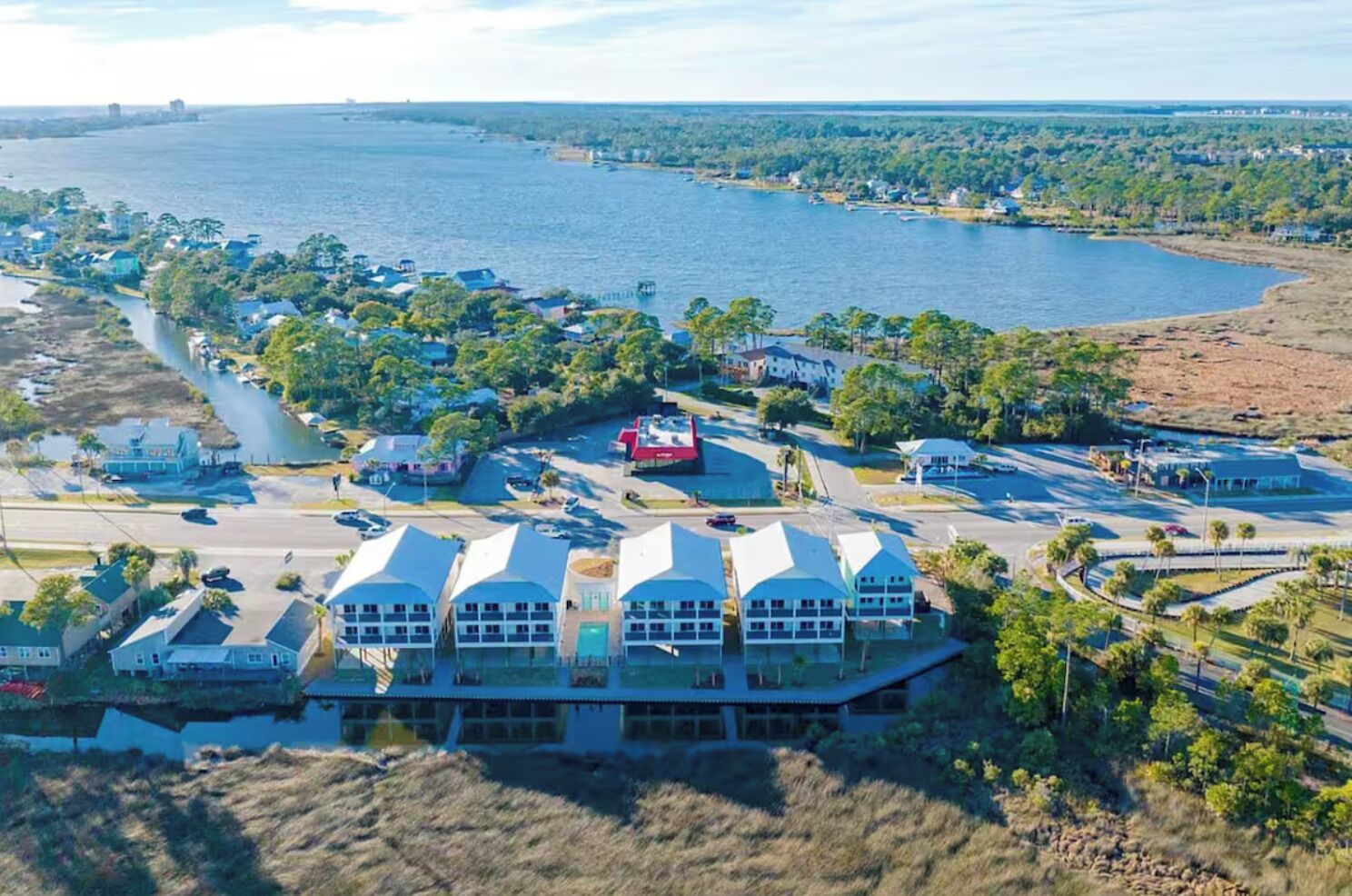 Ein Küstenhotel mit mehreren Gebäuden, einer Marina und einer Straße, die zum Wasser führt.