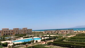 Un complexe hôtelier doté d’une piscine, de plusieurs bâtiments et offrant une vue sur la plage.