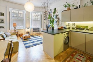 Un apartamento moderno con cocina, comedor y sala de estar. Incluye lavadora, una mesa de comedor con sillas, un sofá y un ventanal con vistas a la ciudad.