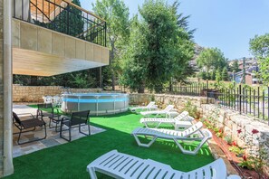 En säsongsöppen utomhuspool och solstolar