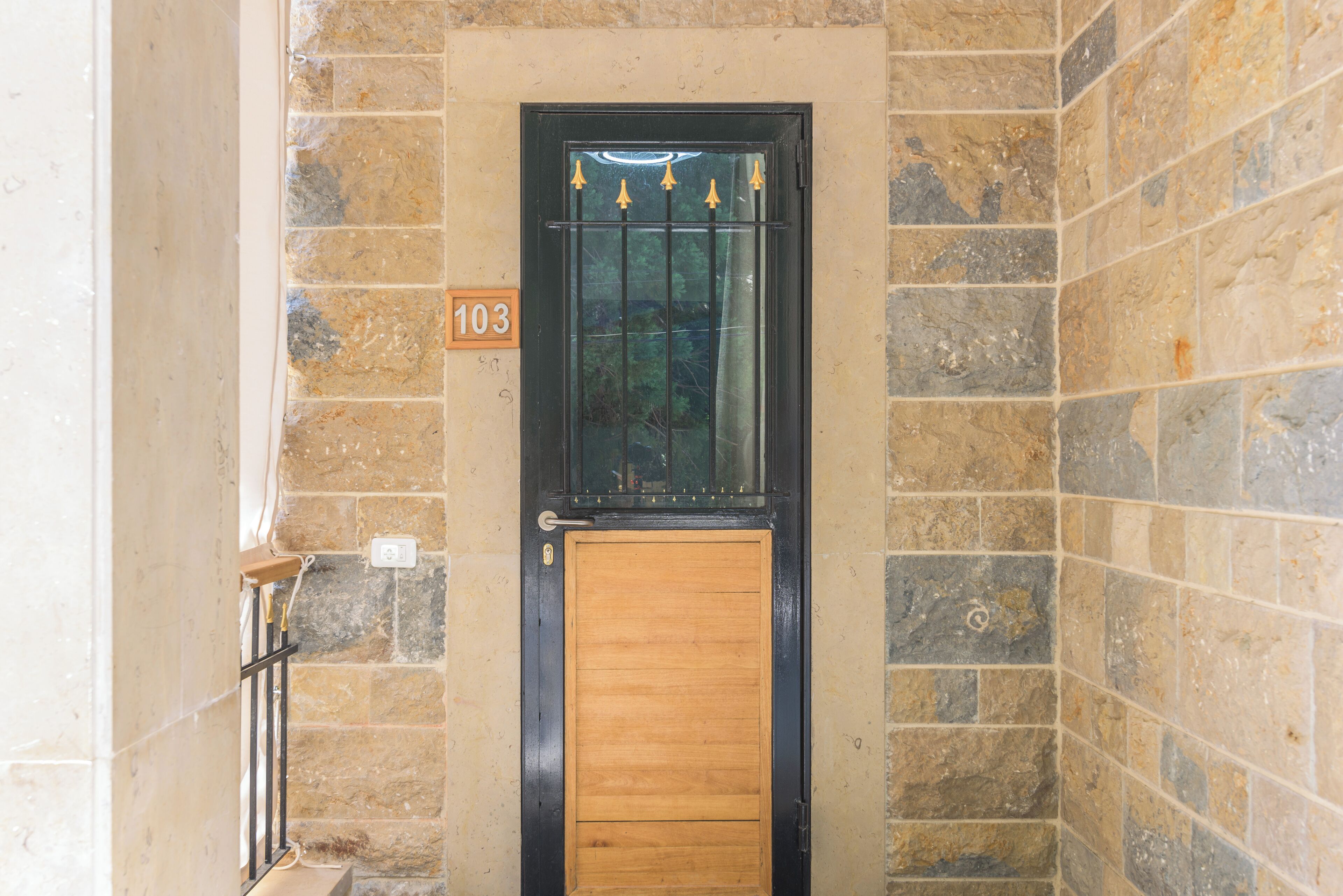 A door with a number plate '103' and a glass panel above it.