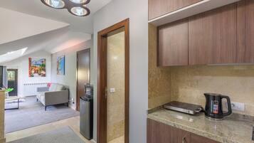 A modern kitchen with wooden cabinets, a countertop, and a kettle.