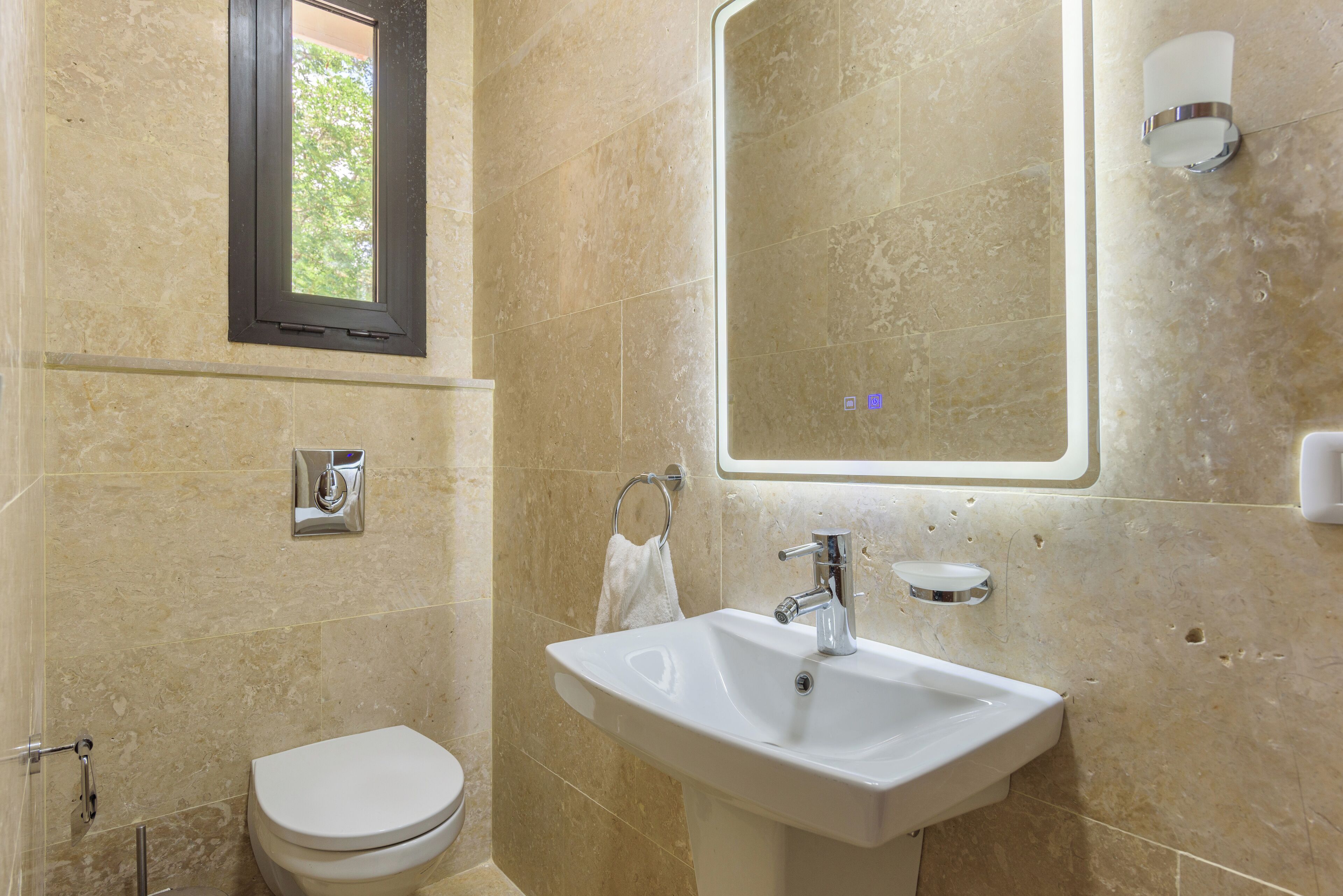 Un baño con inodoro, lavamanos y espejo.