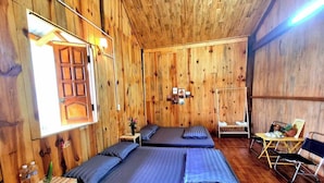 A wooden cabin room with two beds, a small table, and a chair. - Thanh Binh Homestay Mang Den TT Mang Den (Mang Den)