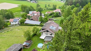 Et landhus med solpaneler, en swimmingpool og en lade.