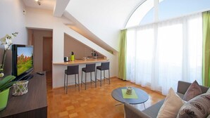 Una sala de estar moderna con cocina, comedor y un ventanal grande.