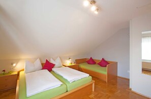 Ein Schlafzimmer mit zwei Betten, jeweils mit Kissen und einem Nachttisch.