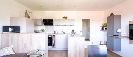 Eine moderne Wohnung mit Küche, Essbereich und Wohnzimmer.