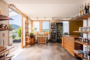 Une cuisine moderne avec des étagères en bois, un îlot central et une vue sur l’extérieur.
