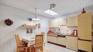 A modern kitchen with wooden cabinets, a dining table with chairs, and a pendant light. - Studio '3' with Private Terrace, Shared Garden and Wi-Fi (Schönwald im Schwarzwald)