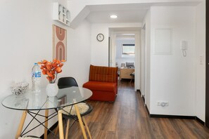 A modern living room with a glass table, a red sofa, and a dining area with a glass table and chairs. - Studio 'Leviq' with Wi-Fi in Gera (Gera)