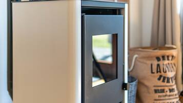 A white refrigerator with a black handle, a small window, and a bag of laundry in the background.