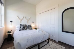 A bedroom with a bed, bedside tables, a wardrobe, and a mirror. - Navigator - 5 mi to XNA - 15 mi to DT Bentonville (Gentry)