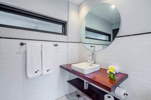 A modern bathroom with a white sink, a mirror, and a towel rack. - w* | Roomy 1BR in Plaza Catedral (Panamá)