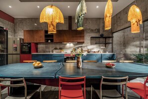 Une cuisine moderne dotée d’un grand îlot central, de luminaires suspendus et d’armoires encastrées.