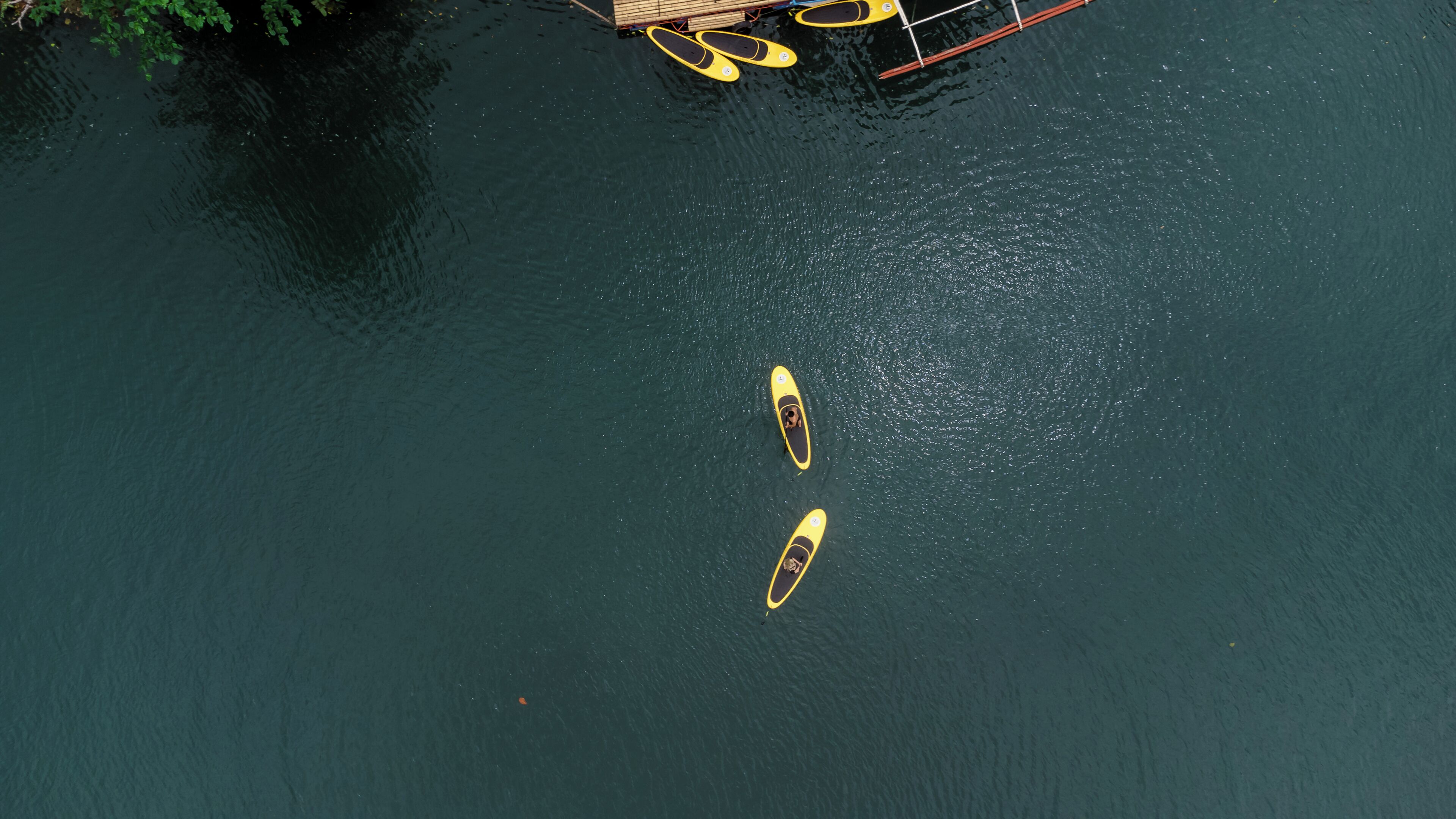 Two kayaks on a calm body of water.