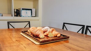 Een houten tafel met een schaal croissants.