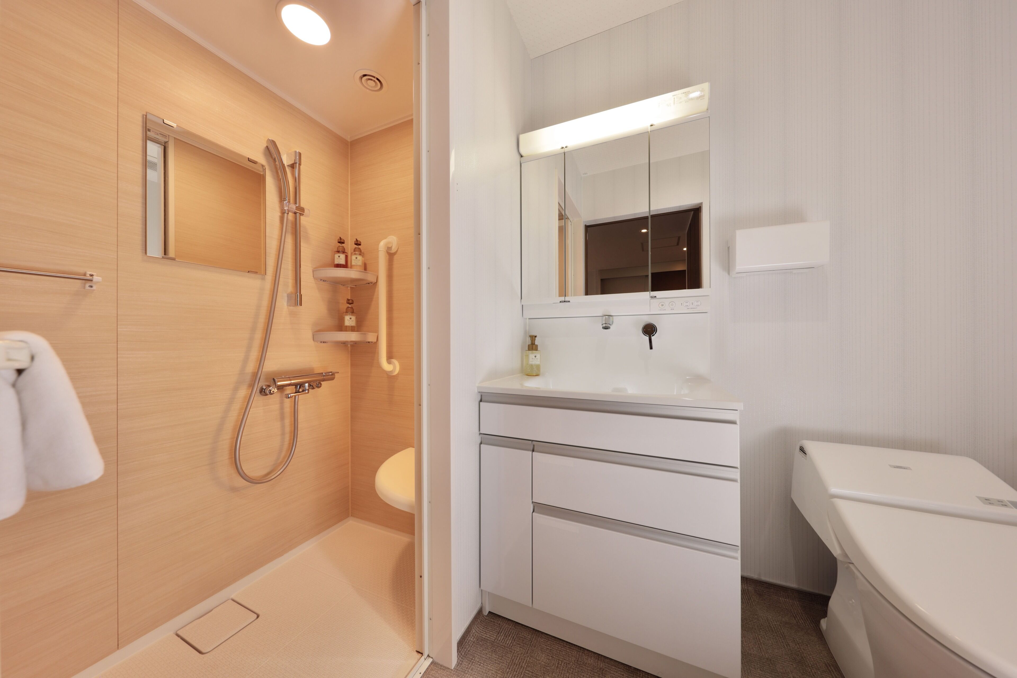 A modern bathroom with a shower, toilet, and sink.