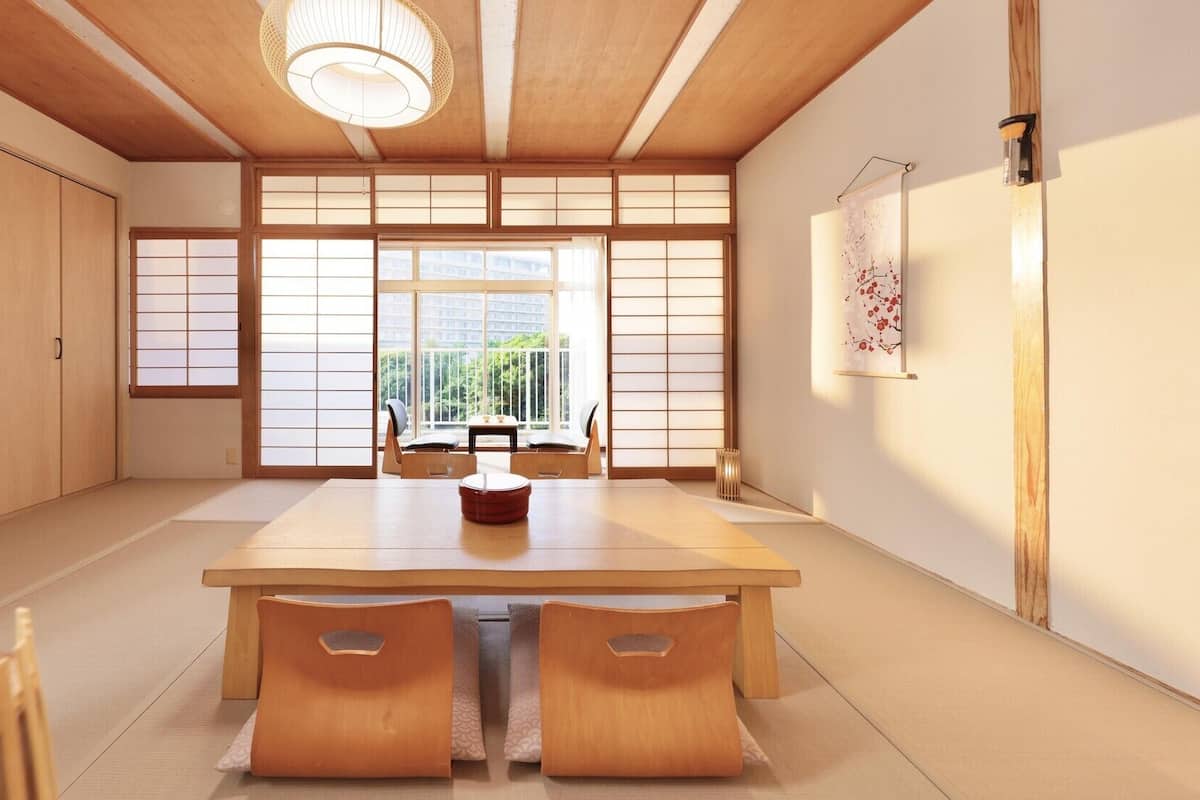 Une pièce de style japonais traditionnel, avec un sol recouvert de tatamis, une table basse et des portes coulissantes.