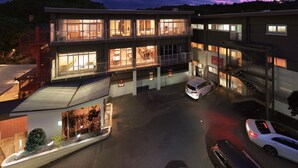 Un hôtel à plusieurs étages doté d’un parking et d’une galerie couverte.