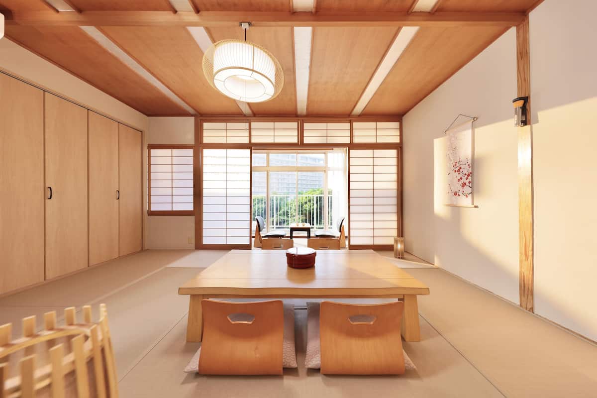 Une pièce de style japonais traditionnel, avec un sol recouvert de tatamis, une basse table en bois et des portes coulissantes.