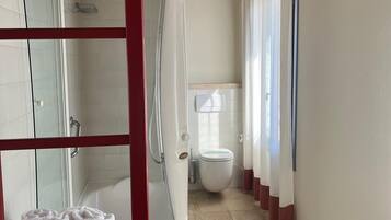 Un baño con ducha, inodoro y bañera.