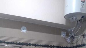 A bathroom with a toilet, a shower, and a water heater.