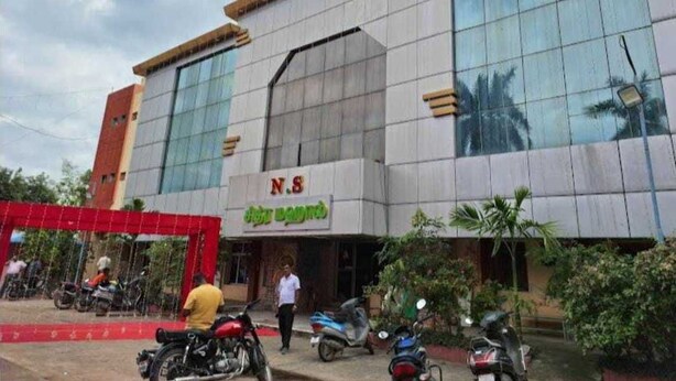 A modern building with a large glass facade and a sign reading "N.S" and "Hotel".