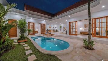 Una casa moderna con piscina, area relax esterna e un giardino curato.