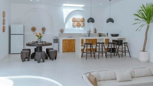 A modern kitchen with a central island, bar stools, and a dining table. - Villa 3BR Summary:<br>VI (pererenan)
