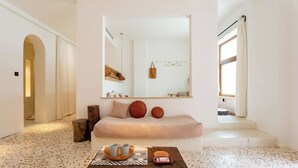 A modern bedroom with a large mirror, a sofa, a small table with cups, and a wooden stool. - Yixi Designer's Boutique Hotel Xi'an (Xi'an)