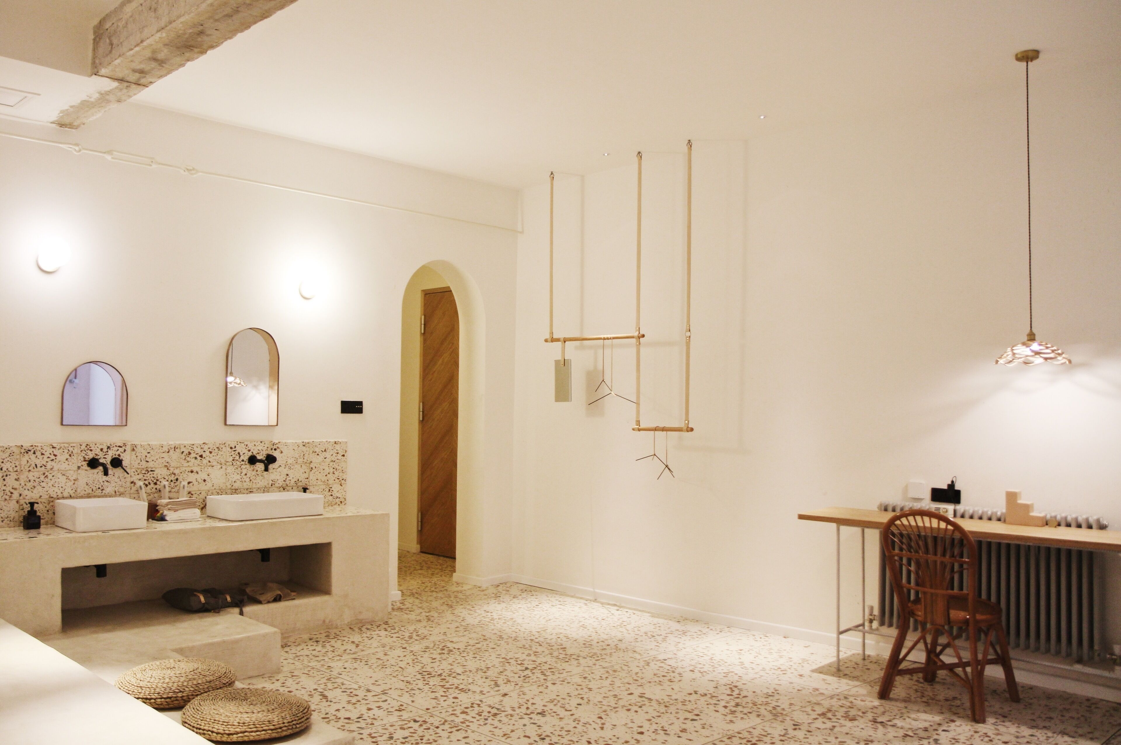 Une salle de bain moderne avec un grand lavabo, des miroirs et une porte en bois.