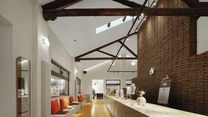 A modern interior with a reception desk, wooden beams, and a patterned wall. - Yixi Designer's Boutique Hotel Xi'an (Xi'an)