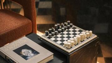 A chessboard on a table with a book beside it.