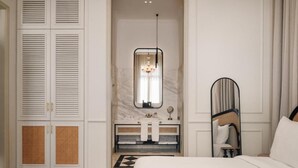 Ein Schlafzimmer mit einem Bett, einem Schminktisch mit Spiegel, einer Chandelier und einem Schrank mit Klappläden.