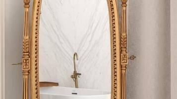 An ornate gold-framed mirror with a checkered floor pattern in the background.