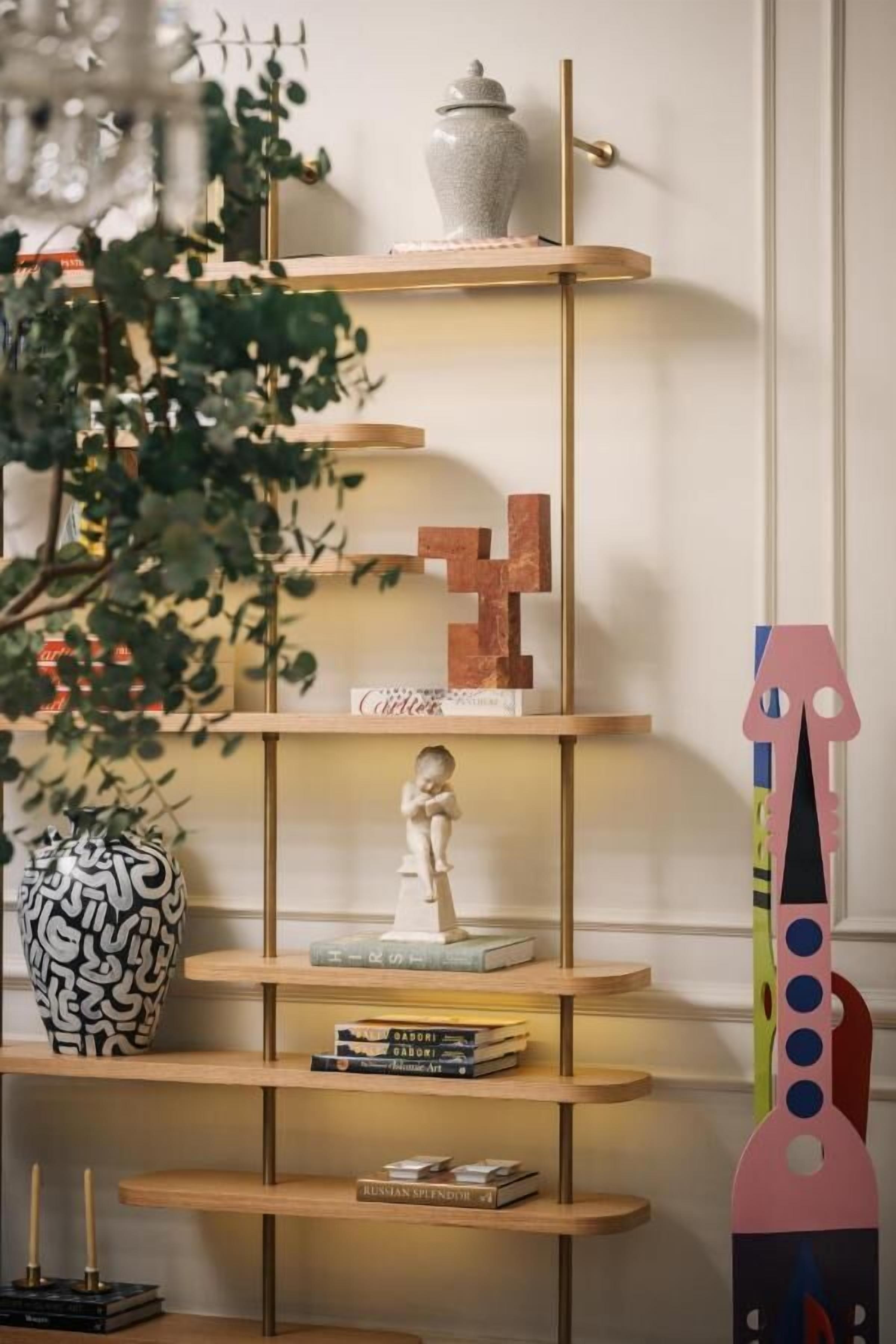 Ein mehrstufiges Holzregal mit Dekoration und Büchern.