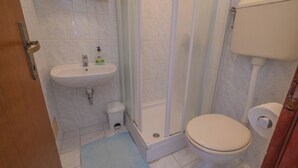 A bathroom with a sink, toilet, and shower. - Apartment Miskic 1 (Jadranovo)