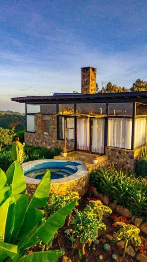 A stone house with a swimming pool, surrounded by lush greenery. - ol eburru cottage naivasha (Naivasha)