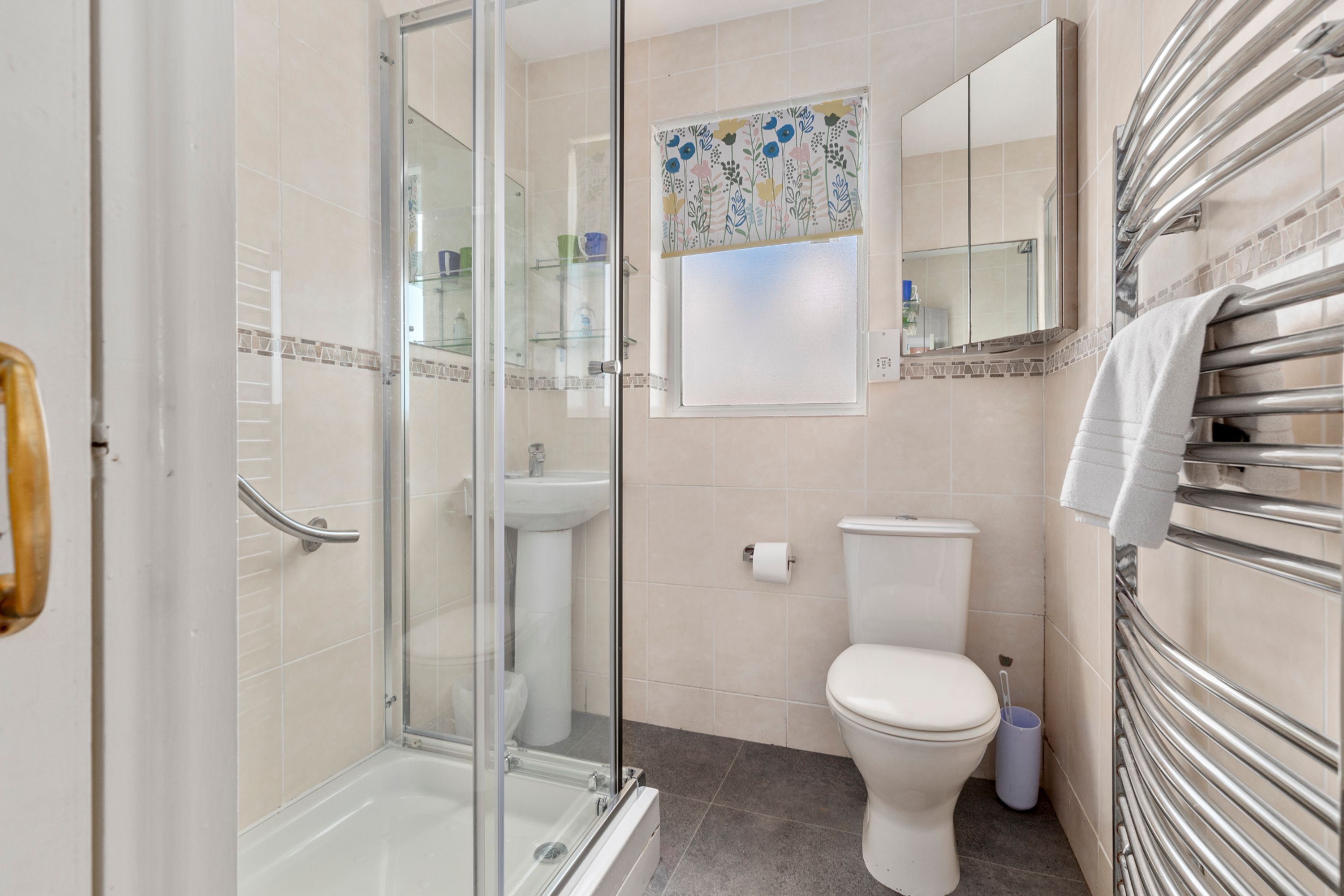 A modern bathroom with a glass shower enclosure, a white toilet, and a built-in sink.