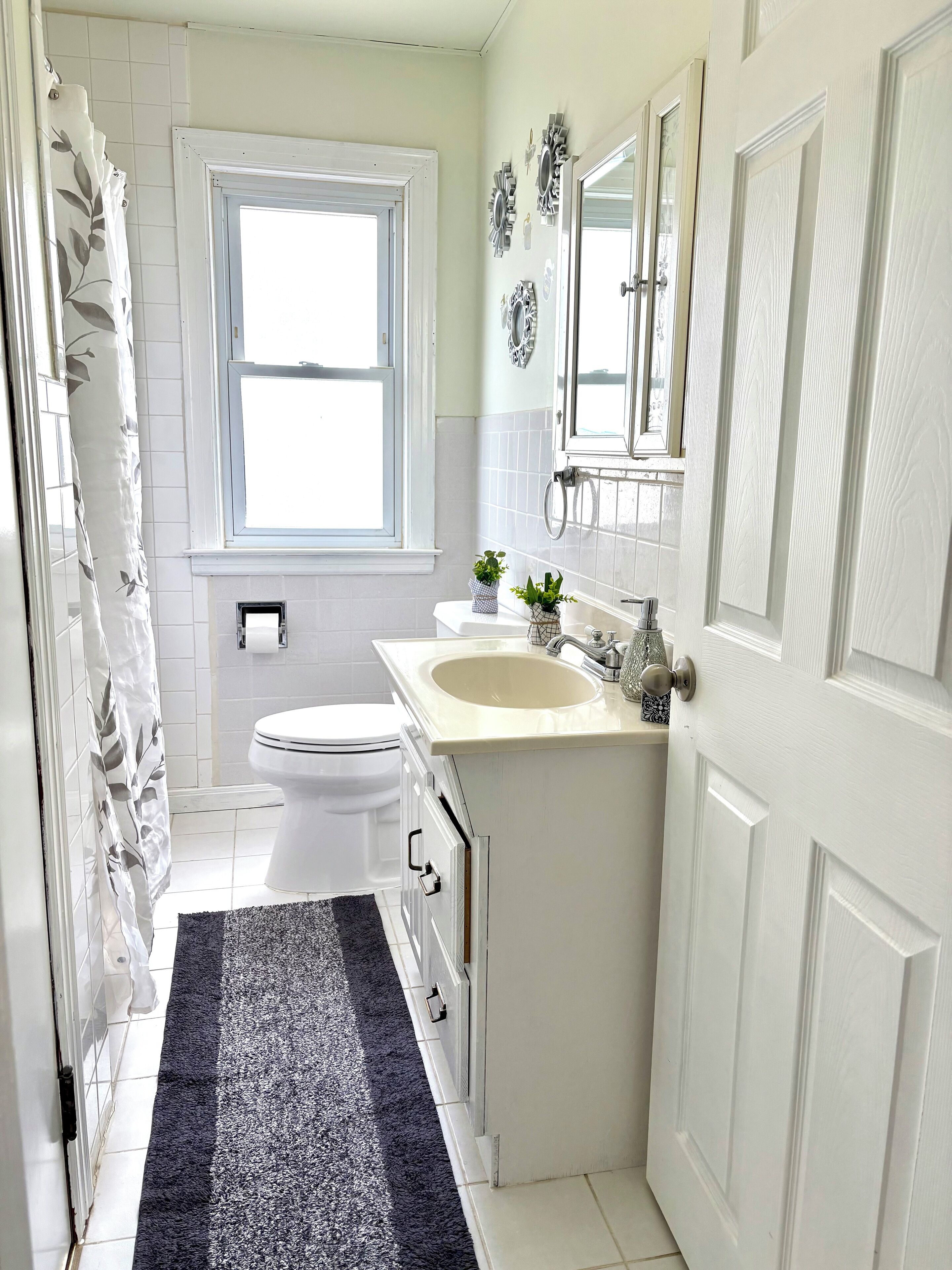 A compact bathroom with a toilet, sink, and shower area.